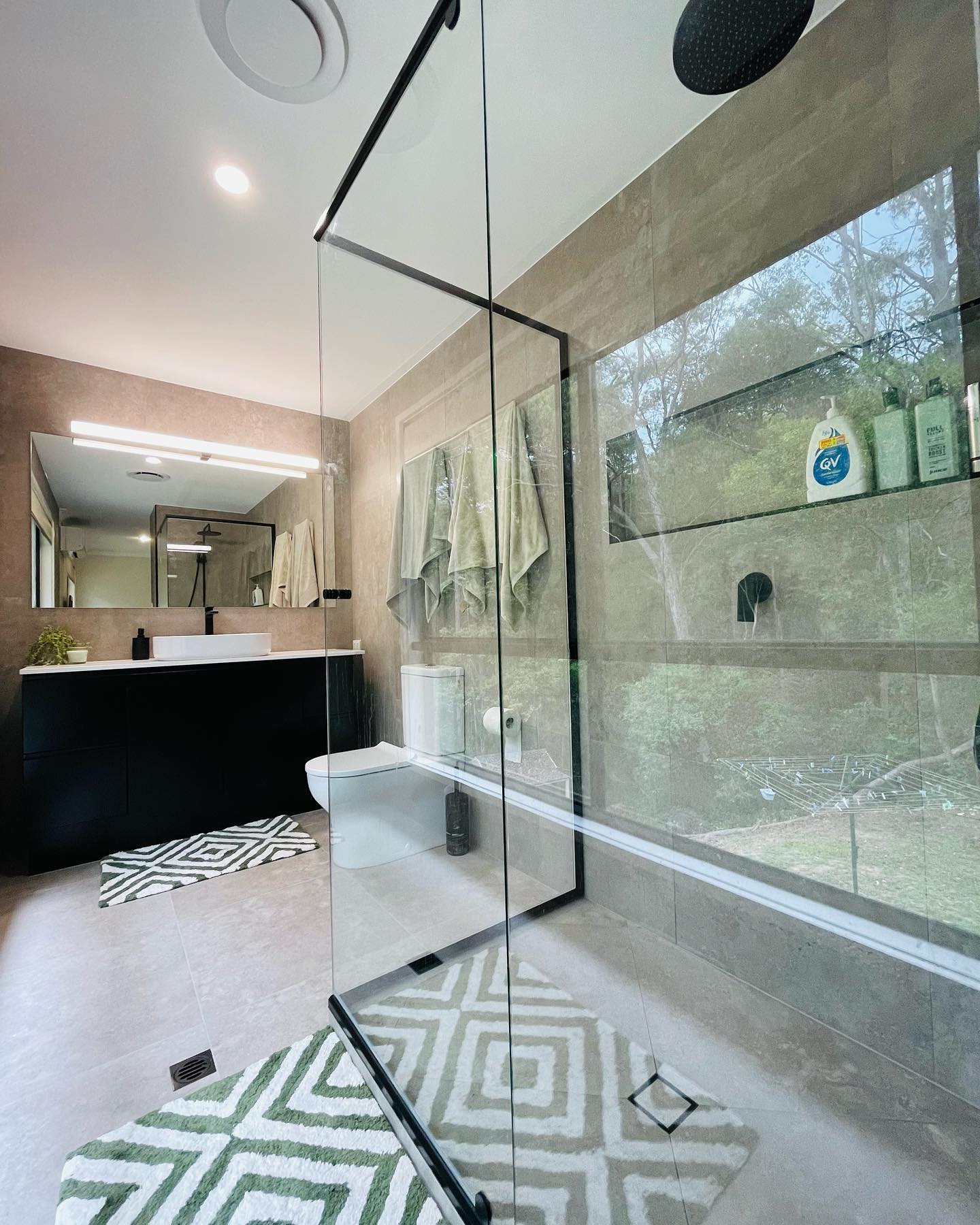 Walk-in shower with picture window to bushland